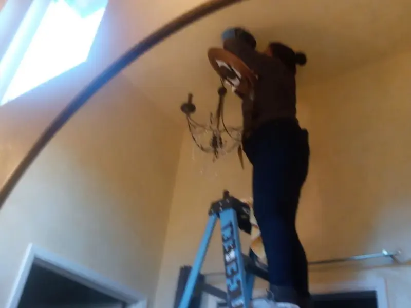 Electrician installing a chandelier in a Mantua residence